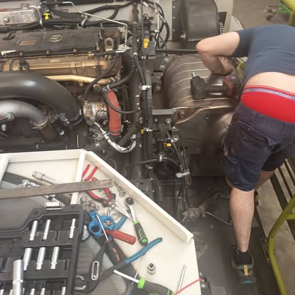 Técnico ReproExtremadura trabajando en motor abierto con herramientas